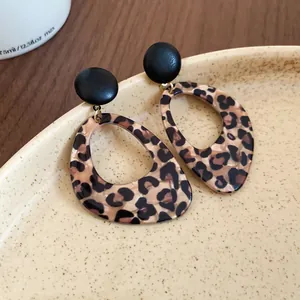 Exquisite close-up showing the leopard print texture of vintage teardrop earrings on a plate