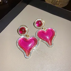Détail macro de boucles d'oreilles vintage en résine en forme de cœur avec strass