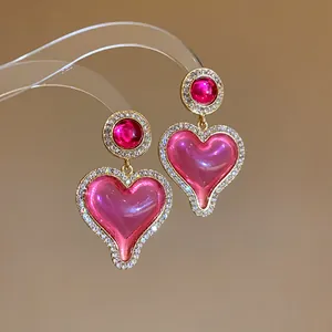 Détail de boucles d'oreilles vintage en forme de cœur avec cristaux et finition dorée
