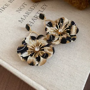 Macro view of leopard print fabric flower earrings with crystal center detail