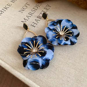 Detail of vintage blue leopard print floral earrings with central rhinestone detail.