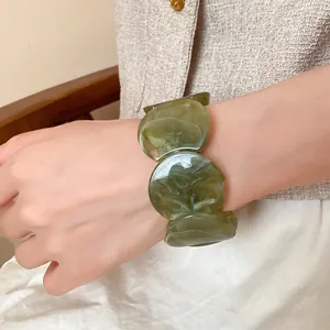 Detailed close-up showing the marbled texture of the green acrylic circular link bracelet