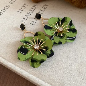 Detailed macro view of vintage green leopard print fabric flower earrings with gold accents