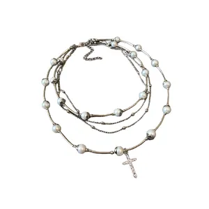 Elegant multi-layer pearl necklace with a sparkling diamond-encrusted cross pendant