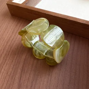 Close-up macro view of olive green marbled acrylic bracelet showing elegant chunky design