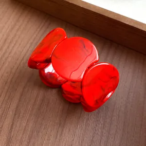 Detailed close-up of a red marbled acrylic segmented bracelet on a wooden background