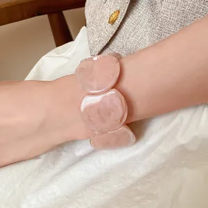 Detail view of pink marble acrylic chunky chain link bracelet on model wrist