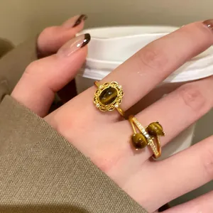 Dettaglio di anelli vintage placcati oro 18k con pietre occhio di tigre e zirconi