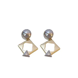 Geometric silver needle earrings with diamond-set rhombus design in gold and silver.