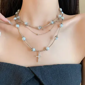 Detail shot of multi-layer pearl necklace with sparkling cross pendant