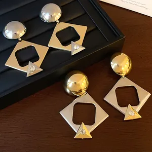 Geometric mixed metal drop earrings with triangle rhinestone detail on a display box