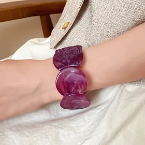 Detail shot of a purple marbled acrylic circular link bracelet on a woman's wrist