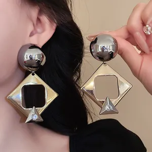 Detail shot of oversized geometric drop earrings with crystals and metallic finish