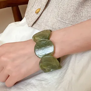 Close-up detail of the green marbled acrylic round segments on this fashion bracelet
