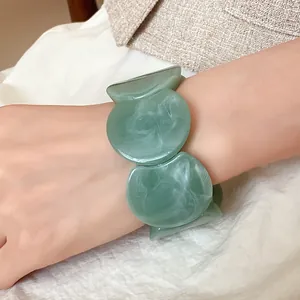 Close-up of a stylish green acrylic marbled bracelet with unique round segment design