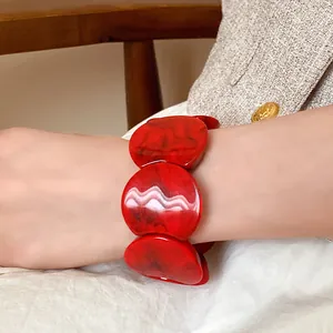Close-up of red marbled acrylic chunky bracelet on wrist