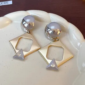 Macro view showing the intricate detail of geometric earrings with gold hollow frames