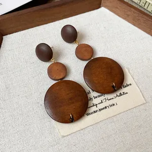Vintage Maillard brown wooden triple circle drop earrings close-up detail on canvas