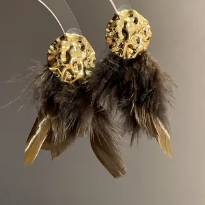 Exaggerated gold hammered stud earrings featuring soft dark brown feather tassels