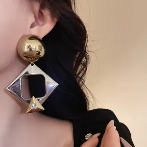 Close-up macro detail of oversized geometric diamond earring with a sparkling rhinestone accent