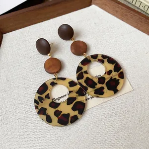Detail view of vintage Maillard leopard print earrings with wooden beads and silver needles.