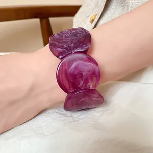 Detailed close-up of a stylish purple marbled acrylic bracelet with round linked segments