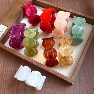 Close-up view of various colorful acrylic bracelets with marbled textures in a tray