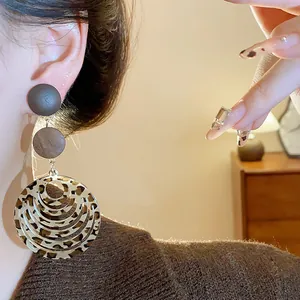 Close-up of retro leopard print layered round earrings with a warm brown aesthetic on model