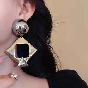 Detailed close-up of geometric hollow diamond drop earrings with sparkling rhinestone