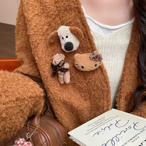 Close-up of cute flocked bear, dog, and kitty brooches on a brown cardigan.