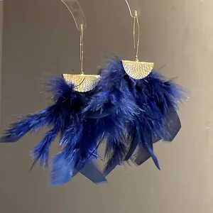 Detailed view of elegant navy blue feather tassel earrings with textured gold finish