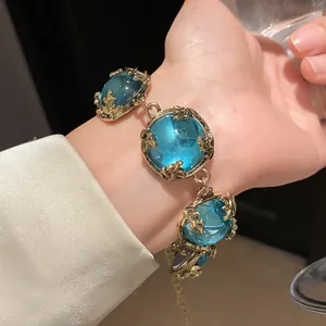 Vintage palace style bracelet with large round blue resin stones in ornate gold setting