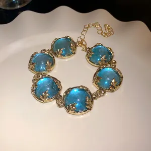 Detailed view of a vintage court-style choker with translucent blue resin cabochons set in gold.