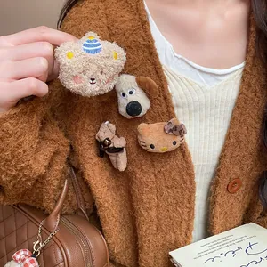 Detailed view of cute flocked bear, cat, and dog brooches pinned on a brown cardigan