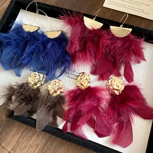 Macro view of pleated feather tassel earrings in diverse colors on a display tray.