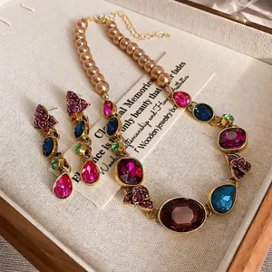 Conjunto de joyas estilo real vintage con pedrería de colores y perlas champagne
