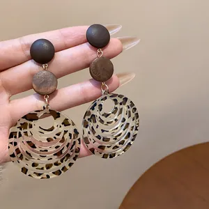 Detailed view of vintage leopard print acrylic earrings with stylish wooden studs
