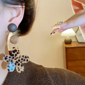 Close-up detail of vintage wooden leopard print flower earring with brown acrylic petals