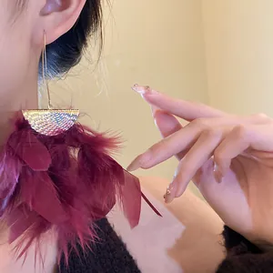 Exaggerated burgundy feather tassel earrings with golden hammered metal finish