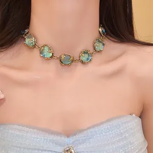 Vintage palace style choker featuring green resin stones and gold branch metal details