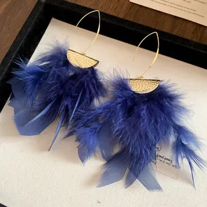 Detailed macro view of elegant blue feather tassel earrings with pleated gold finish.