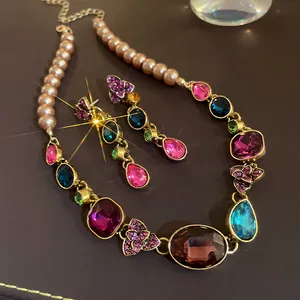 Detalle de conjunto de joyas estilo palacio vintage con gemas de colores y perlas