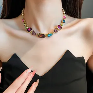 Vista detallada de collar vintage con gemas de colores en el cuello de la modelo