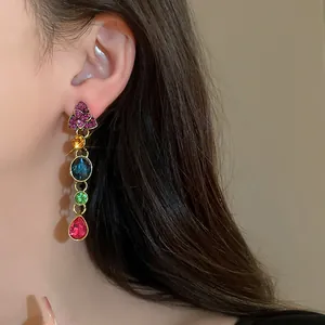 Primer plano detallado de pendientes vintage de borla con flores y pedrería de colores
