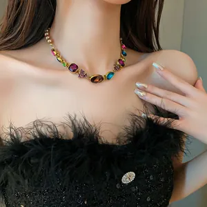 Primer plano de un collar dorado de estilo palacio vintage con cristales de colores
