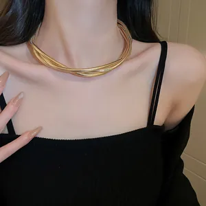 Close-up of elegant layered golden snake chain necklace worn on a female model's neck