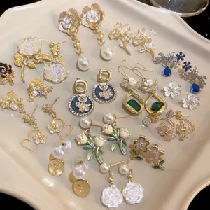 Macro view of various vintage style floral pearl earrings with elegant golden finishes