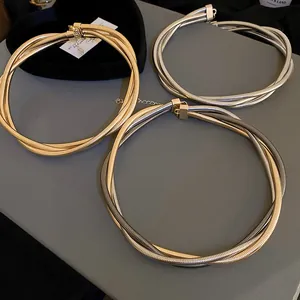 Close-up of twisted metal snake chain necklaces in gold and silver finishes