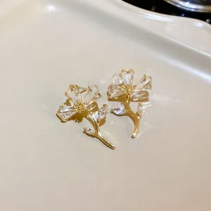 Detailed view of elegant flower stud earrings with clear crystals and golden branch design