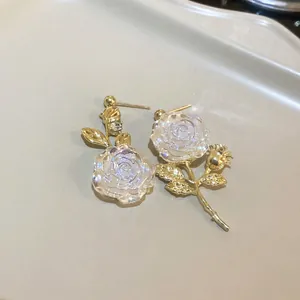 Close-up of vintage gold rose earrings with iridescent translucent petals